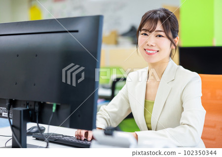 Young woman working with a computer in the office Young woman working with a computer in the office 102350344