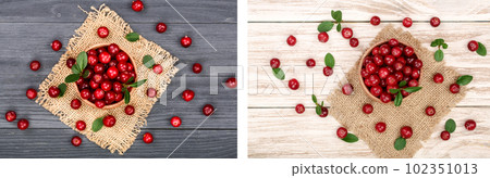Cranberry with leaf in wooden bowl on black wooden background. Top view 102351013