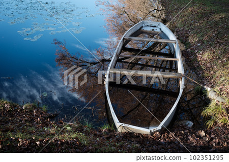 Old wooden boat full of water on lake Old wooden boat full of water on lake 102351295