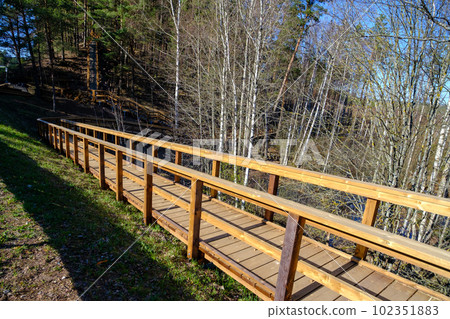 Wooden stairs with elevated walkway under construction, new construction, wooden structure, nature trail in forest. Wooden stairs with elevated walkway under construction, new construction, wooden structure, nature trail in forest. 102351883
