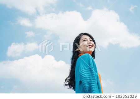一個20多歲的女人微笑著仰望藍天 102352029