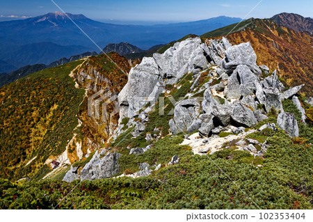 View of the main ridgeline of autumn foliage and Mt. Ontake and Mt. Norikura seen from the summit of Mt. View of the main ridgeline of autumn foliage and Mt. Ontake and Mt. Norikura seen from the summit of Mt. 102353404