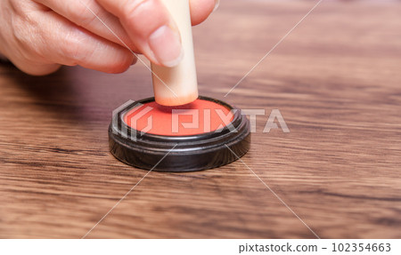 [Woman putting ink on seal] 102354663