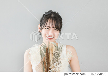 A smiling Japanese woman with a bouquet (birthday, gift, Mother's Day) 102355053