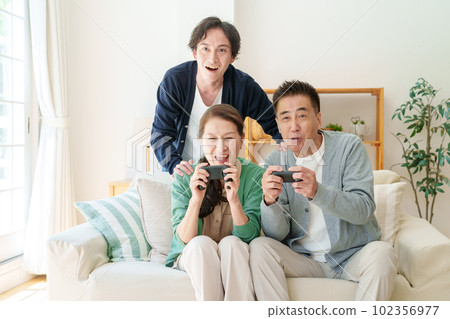 Senior couple playing video games in the living room Senior couple playing video games in the living room 102356977