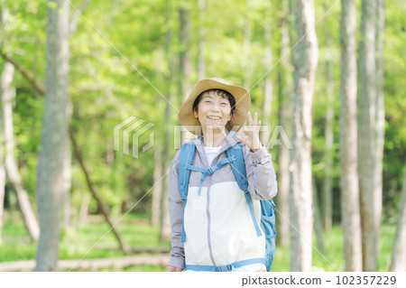 一位高級女性在新綠色中徒步旅行的照片 102357229