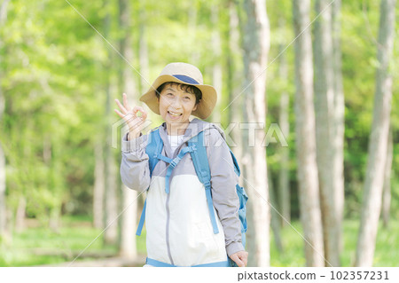 一位高級女性在新綠色中徒步旅行的照片 102357231