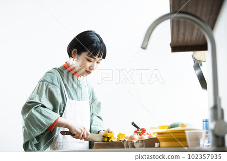 一個女人用菜刀切扭扭的南瓜 一個女人用菜刀切扭扭的南瓜 102357935