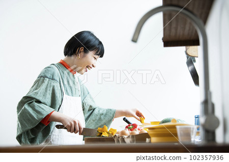 一個女人用菜刀切扭扭的南瓜 一個女人用菜刀切扭扭的南瓜 102357936