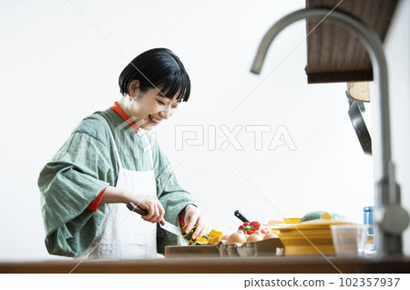 一個女人用菜刀切扭扭的南瓜 102357937