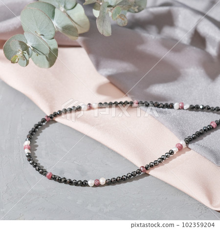 close up view of seed bead necklace on silk fabric background. handmade choker boho style close up view of seed bead necklace on silk fabric background. handmade choker boho style 102359204