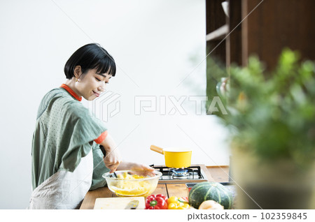 Young woman making pumpkin pancakes Young woman making pumpkin pancakes 102359845