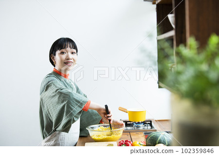 Young woman making pumpkin pancakes Young woman making pumpkin pancakes 102359846