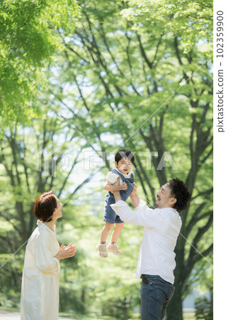 A child and a happy family who have a high high in the fresh green A child and a happy family who have a high high in the fresh green 102359900