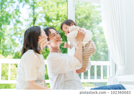 一對夫婦舉起一個嬰兒 一對夫婦舉起一個嬰兒 102360083