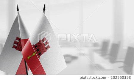 Small flags of the Gibraltar on an abstract blurry background Small flags of the Gibraltar on an abstract blurry background 102360338