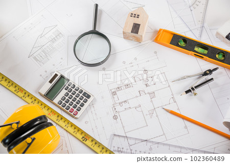 Architectural project workplace. Top view of house plan blueprint paper with repair tools on table desk at architecture office, Engineering architect design tools concept Architectural project workplace. Top view of house plan blueprint paper with repair tools on table desk at architecture office, Engineering architect design tools concept 102360489