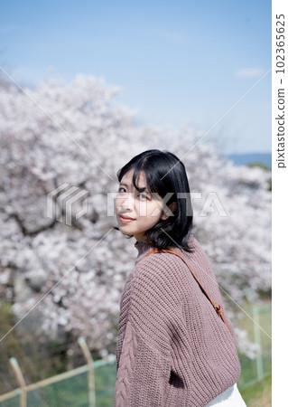 一個女人微笑著看櫻花 一個女人微笑著看櫻花 102365625