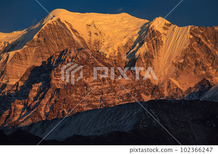 Nilgiri peak at sunset looking up from a village along the Jomsom Highway, Nepal Nilgiri peak at sunset looking up from a village along the Jomsom Highway, Nepal 102366247