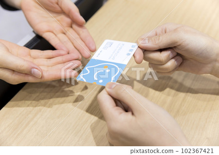 一位年輕女子在牙醫的接待處遞諮詢票 102367421