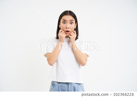 Portrait of shocked, scared asian woman, gasping and jumping scared, white background 102368228