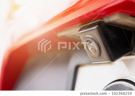 Red car rear view camera close up for parking assistance 102368259