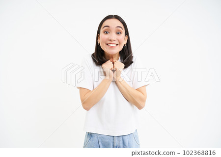 Smiling asian woman looking hopeful, seeing something with excitement, white background Smiling asian woman looking hopeful, seeing something with excitement, white background 102368816