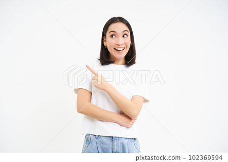 Portrait of beautiful smiling asian woman, pointing finger left, showing advertisement, recommending website, isolated on white background Portrait of beautiful smiling asian woman, pointing finger left, showing advertisement, recommending website, isolated on white background 102369594