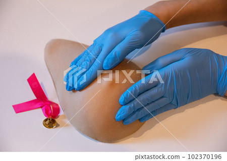 Pinch compression with the whole hand and both palms of the breast on the phantom of Lady M. 102370196