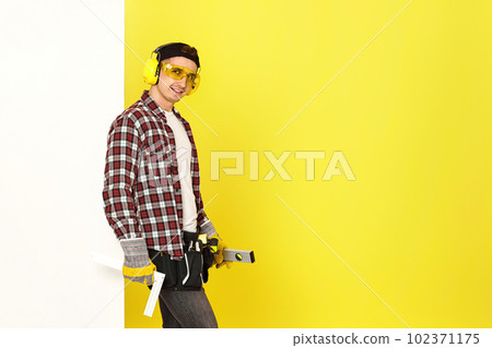 Worker man or builder in construction helmet near white banner 102371175