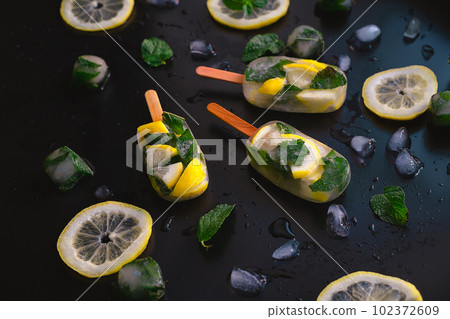 Refreshing Fruit Ice pops with Lemon and Mint on Dark Background 102372609