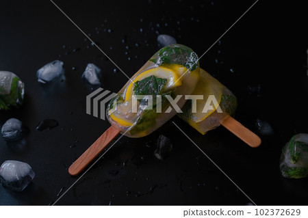 Lemon Infused Fruit Ice on a Black Background 102372629