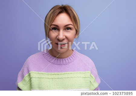 bright joyful energetic blond woman in a casual striped sweater on a purple background bright joyful energetic blond woman in a casual striped sweater on a purple background 102373895