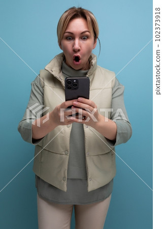 smiling surprised attractive blond girl showing blank smartphone screen with mockup for web page on 102373918