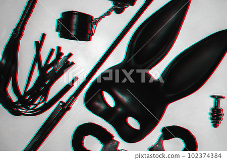 Handcuffs, whip flogger for BDSM sex with submission and domination. A set of adult intimate erotic sex toys 102374384