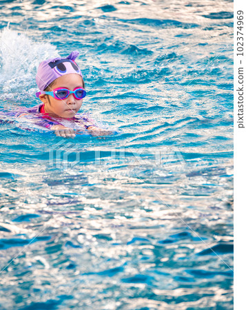 Asian child or kid girl wearing swimming suit to learning on swimming pool , learn and training swim on kick board Asian child or kid girl wearing swimming suit to learning on swimming pool , learn and training swim on kick board 102374969