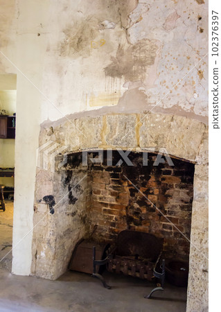 A fireplace with a very old and dirty red brick wall The white interior of Oxford 102376397