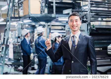Businessman pointing finger in factory Businessman pointing finger in factory 102376629
