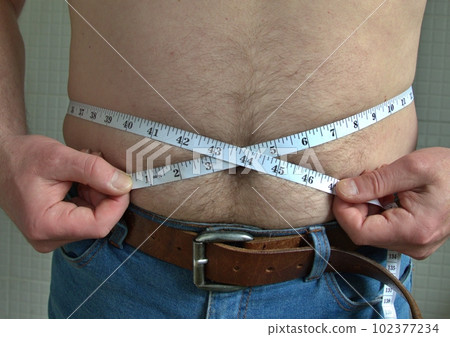 Man's waistline being measured Man's waistline being measured 102377234