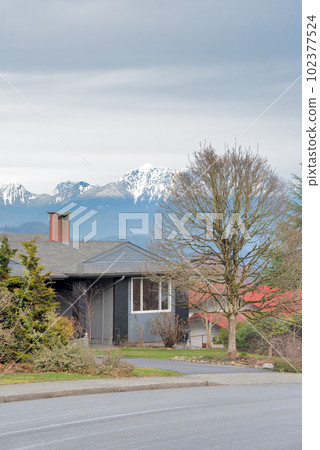Residential house on winter season with mountain view on the background Residential house on winter season with mountain view on the background 102377524