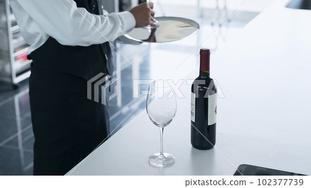 A man carrying a wine bottle and a wine glass, a sommelier, a wine expert A man carrying a wine bottle and a wine glass, a sommelier, a wine expert 102377739