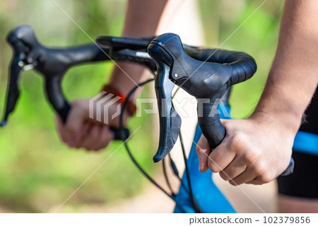 Hands of an athlete during a cycling race. 102379856