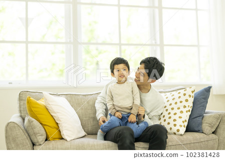 父母和孩子坐在沙發上 102381428