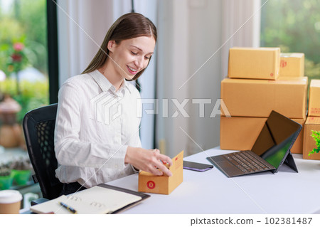 Concept of parcel delivery and selling online,Retailer Using a calculator to calculate sales for the day on an online store for pack into the parcel box and prepare to send the product to the customer Concept of parcel delivery and selling online,Retailer Using a calculator to calculate sales for the day on an online store for pack into the parcel box and prepare to send the product to the customer 102381487