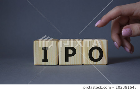 IPO- Initial Public Offering symbol. Concept word IPO on wooden cubes. Businessman hand. Beautiful grey background. Business and IPO concept. Copy space. 102381645