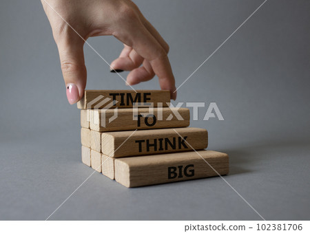 Time to think big symbol. Wooden blocks with words Time to think big. Beautiful grey background. Businessman hand. Business and Time to think big concept. Copy space. 102381706