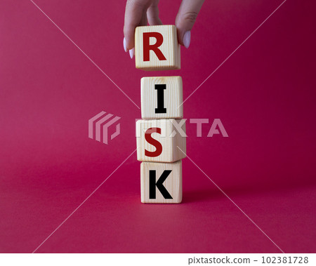 Risk symbol. Concept word Risk on wooden cubes. Businessman hand. Beautiful red background. Business and Risk concept. Copy space. 102381728