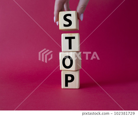 Stop symbol. Concept word Stop on wooden cubes. Businessman hand. Beautiful red background. Business and Stop concept. Copy space. 102381729