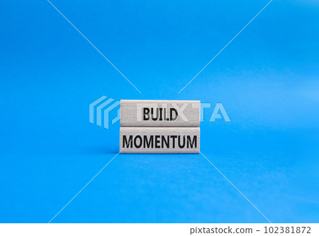 Build momentum symbol. Wooden blocks with words Build momentum. Beautiful blue background. Business and Build momentum concept. Copy space. Build momentum symbol. Wooden blocks with words Build momentum. Beautiful blue background. Business and Build momentum concept. Copy space. 102381872