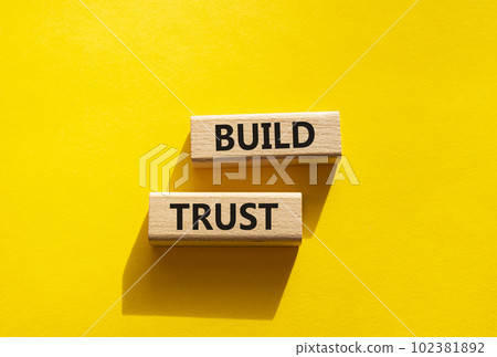 Build trust symbol. Wooden blocks with words Build trust. Beautiful yellow background. Business and Build trust concept. Copy space. 102381892
